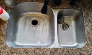 Tired of a dirty looking sink? Learn how to make your own DIY kitchen sink cleaner for your stainless steel sink or white porcelain sink. These cleaning tips using baking soda, lemon, and essential oils make quick work of stuck on messes. Learn how to clean a stainless steel sink with your own homemade sink cleaning scrub. Click to get your sink cleaning hacks and get a clean sink again! @naturalsoapmom.com #sinkcleaner #kitchencleaning #kitchencleaningkits #kitchencleaner #sinkscrub #kitchensinkclean #cleankitchen #cleankitchenatnight #cleankitchens #sinkcleaning #cleankitchens #dirtysink #dirtysinks #stainedsink #allnatural #sanitize